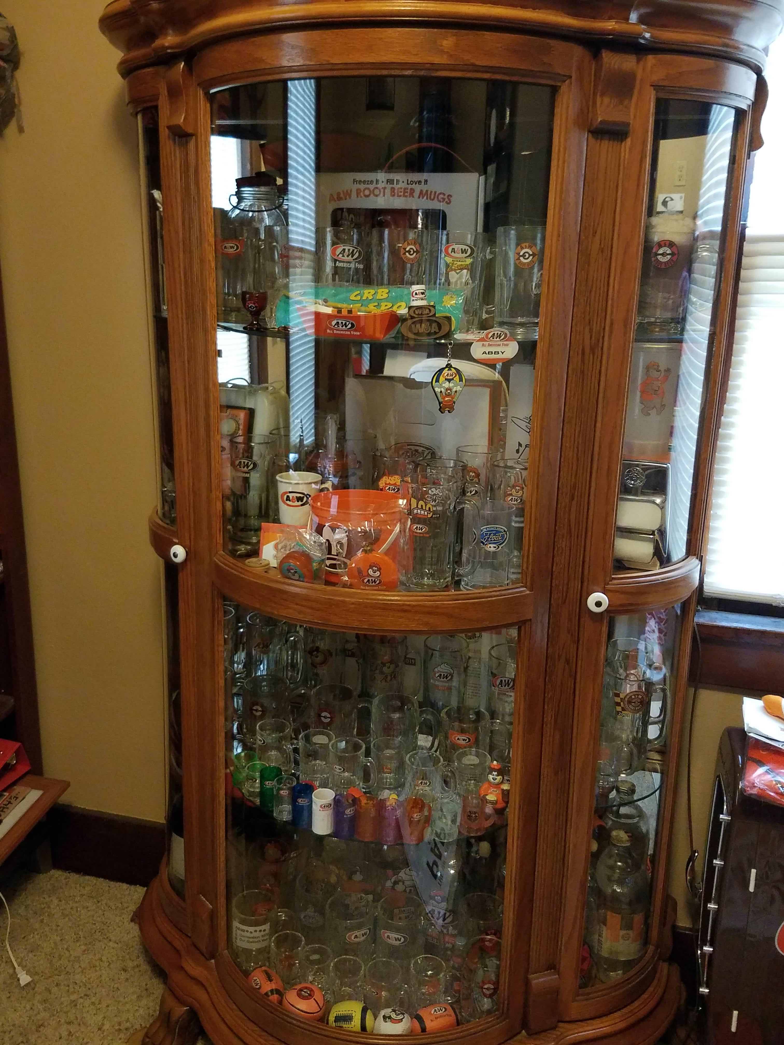 Photo of a display case containing various A&W Restaurants memorabilia and mugs.