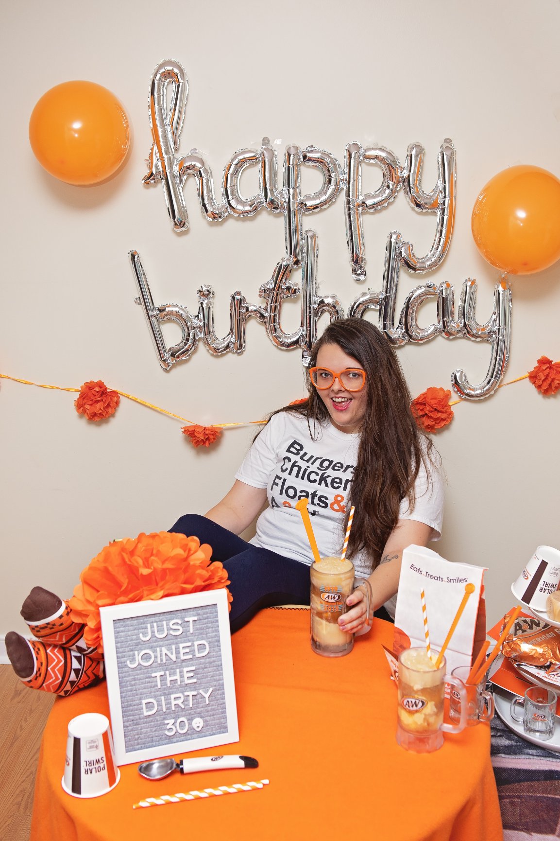 Briana sitting at table with A&W merchandise