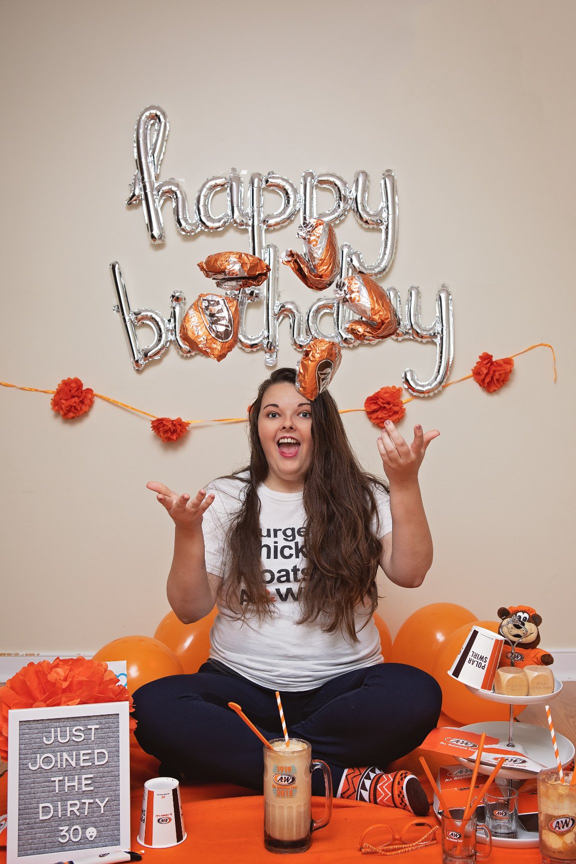 Briana throwing A&W packaging into the air